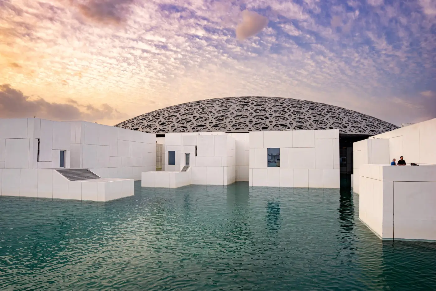 Louvre Abu Dhabi and its domed roof over the water at sunset